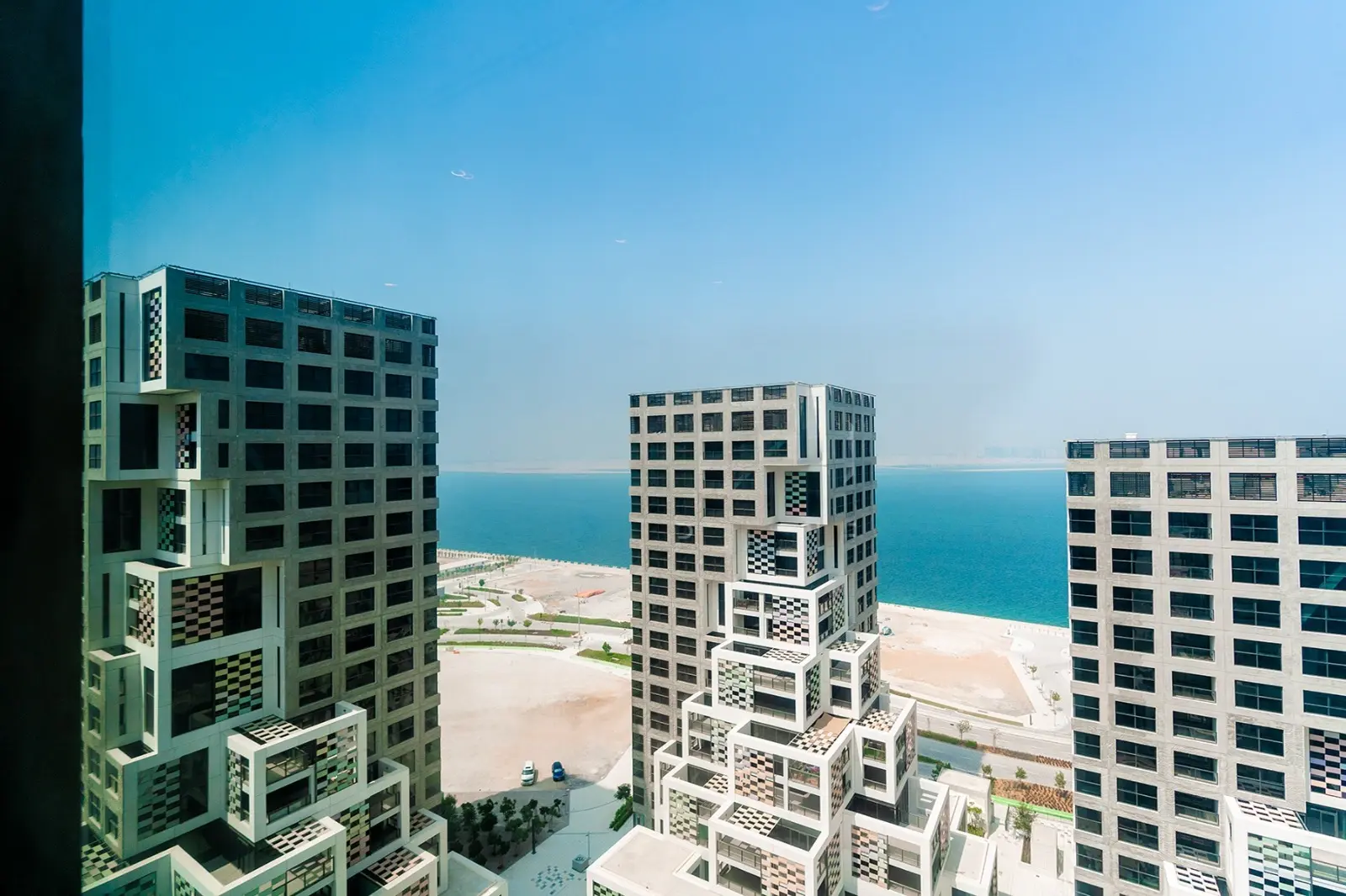 Pixel Al Reem Island exterior featuring modern waterfront buildings, vibrant public spaces, and contemporary urban design.