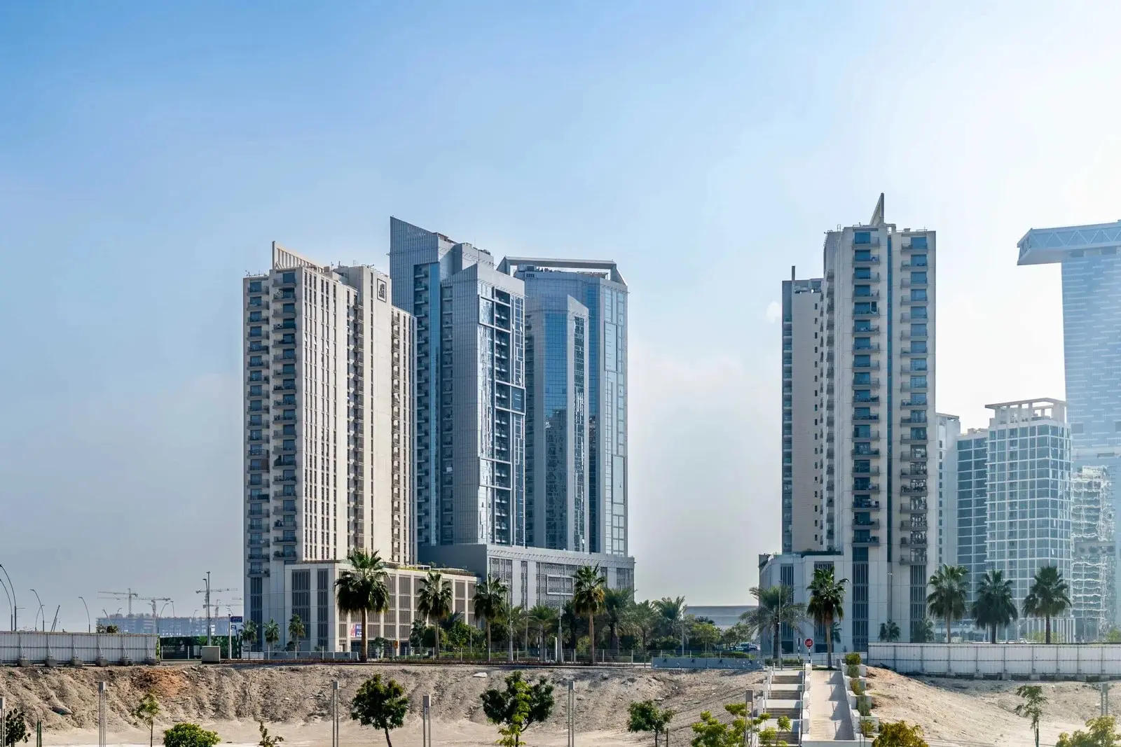 Reflection Tower high-rise exterior at Al Reem Island Abu Dhabi overlooking landscaped parks and waterfront community.